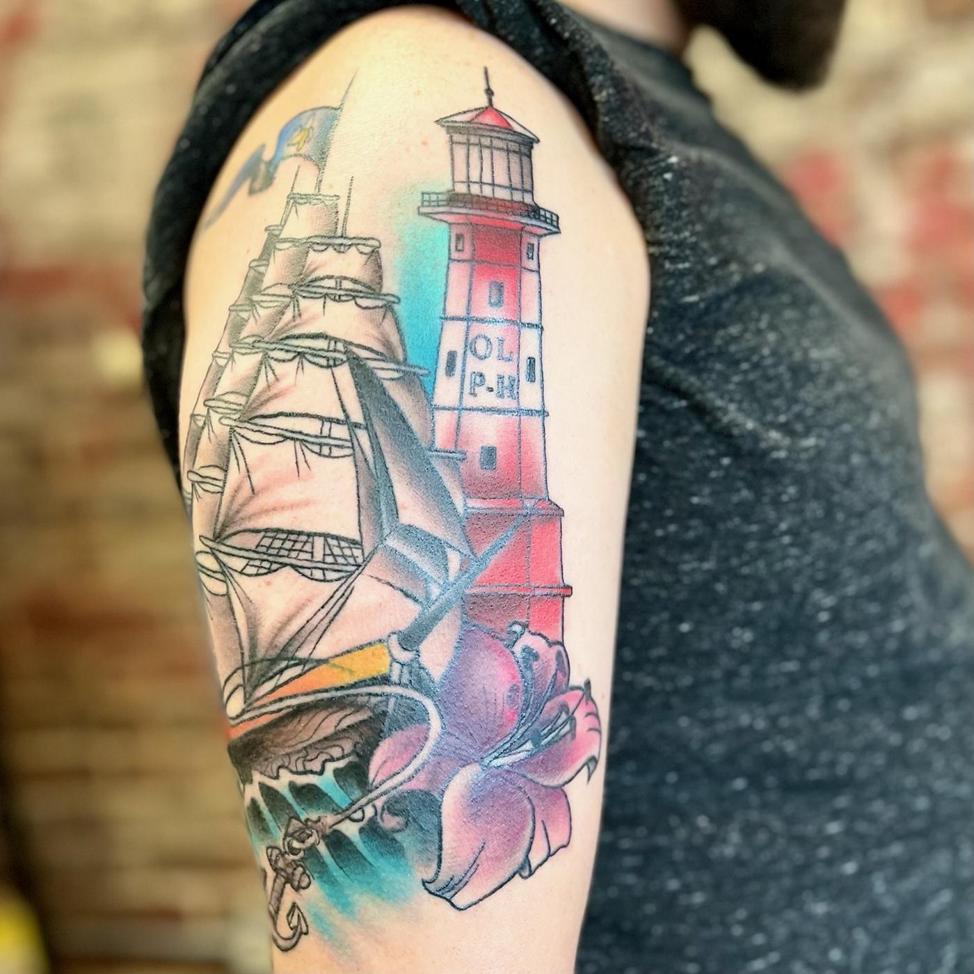 Colour tall ship and lighthouse with a lily, on an upper arm.